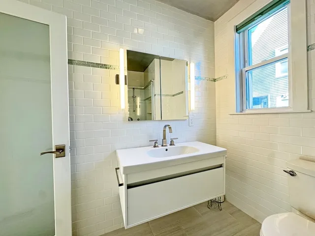 a open kitchen with white cabinets and white appliances