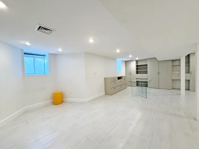 a view of a hallway with wooden floor and furniture