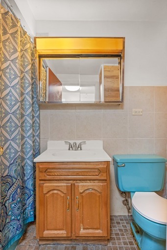 8809 North Dee Road Des Plaines, IL 60016 - Photo 7 of 16 a bathroom with a sink a toilet and a mirror