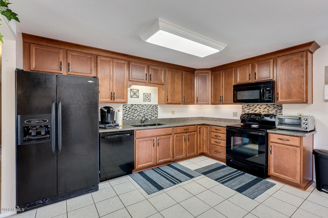 3452 East Nisbet Road Phoenix, AZ 85032 - Photo 14 of 31 a kitchen with stainless steel appliances granite countertop a refrigerator and a stove top oven