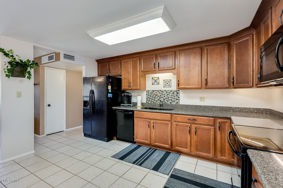 3452 East Nisbet Road Phoenix, AZ 85032 - Photo 15 of 31 a kitchen with stainless steel appliances granite countertop a refrigerator and a sink