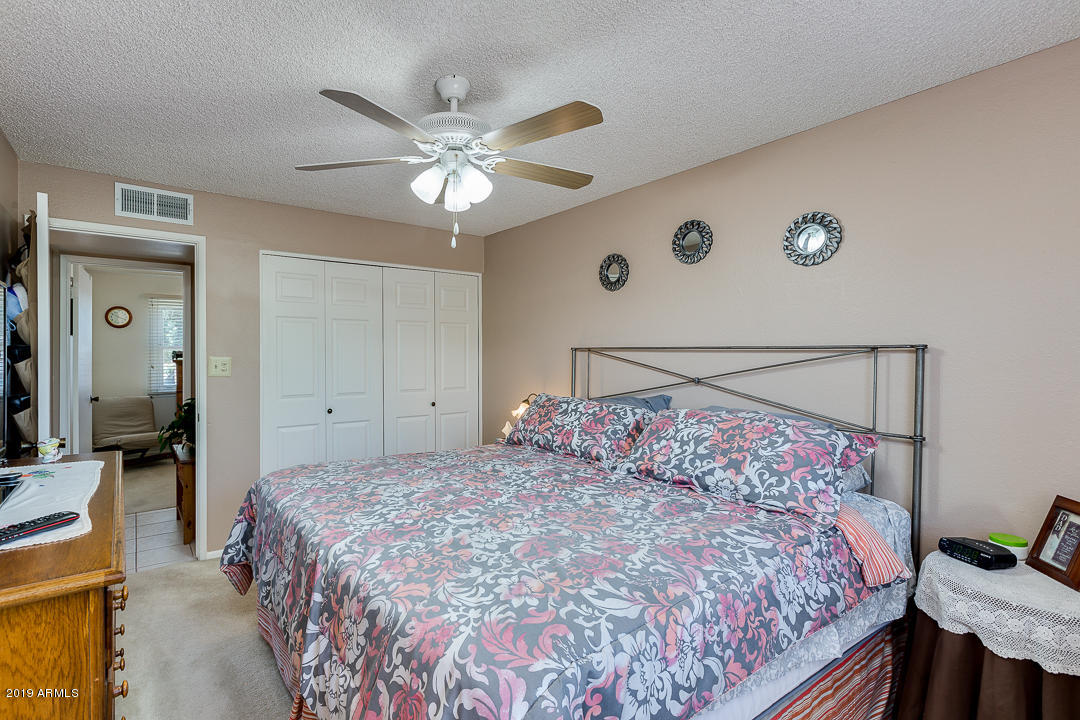 3452 East Nisbet Road Phoenix, AZ 85032 - Photo 18 of 31 a bedroom with a large bed and a chandelier