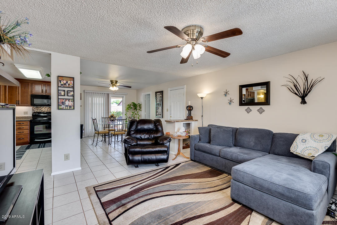3452 East Nisbet Road Phoenix, AZ 85032 - Photo 5 of 31 a living room with furniture a ceiling fan and a rug
