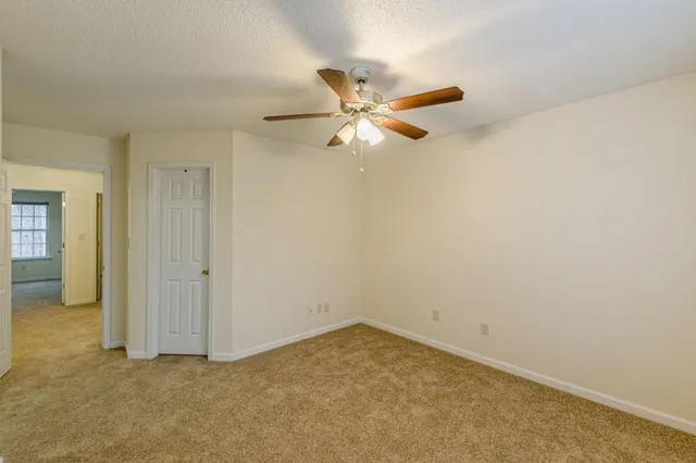 an empty room with a ceiling fan and a window