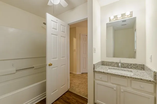 a bathroom with a granite countertop sink and a mirror