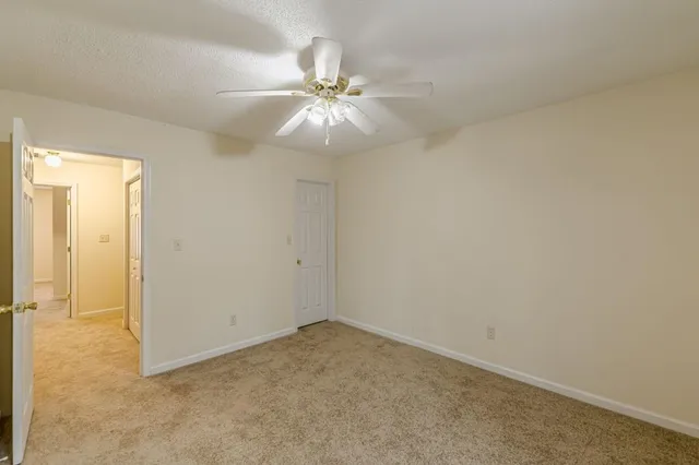 an empty room with a ceiling fan and a window