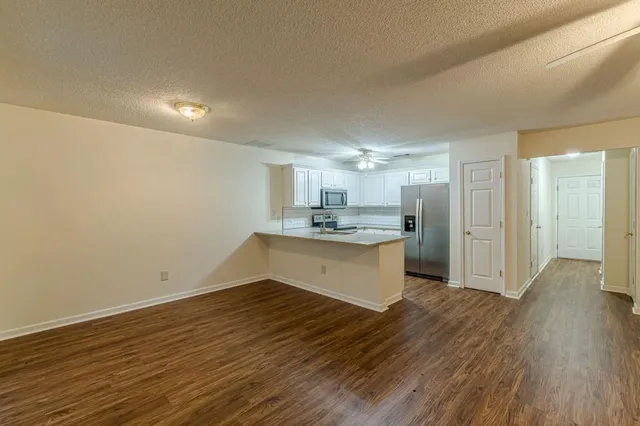 a large kitchen with a wooden floor and cabinets