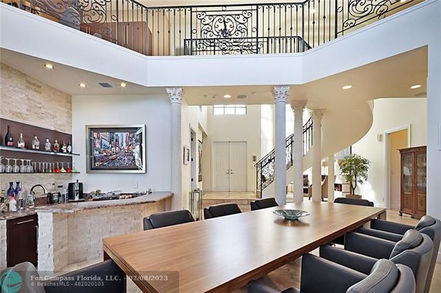 a living room with stainless steel appliances furniture a refrigerator and a kitchen view