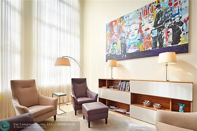 a living room with furniture and a painting on the wall