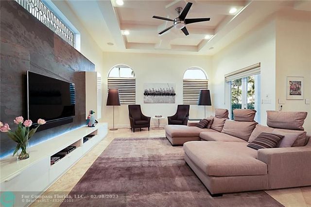 a living room with furniture a large window and a flat screen tv