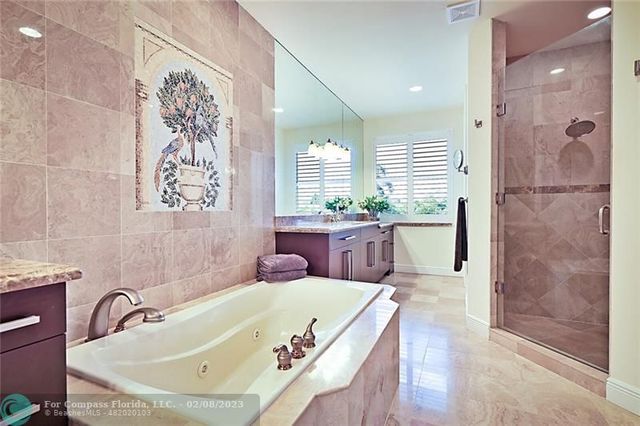 a bathroom with a tub sink and mirror