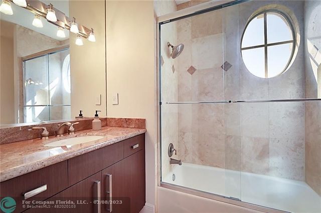 a bathroom with a granite countertop sink a mirror and a shower