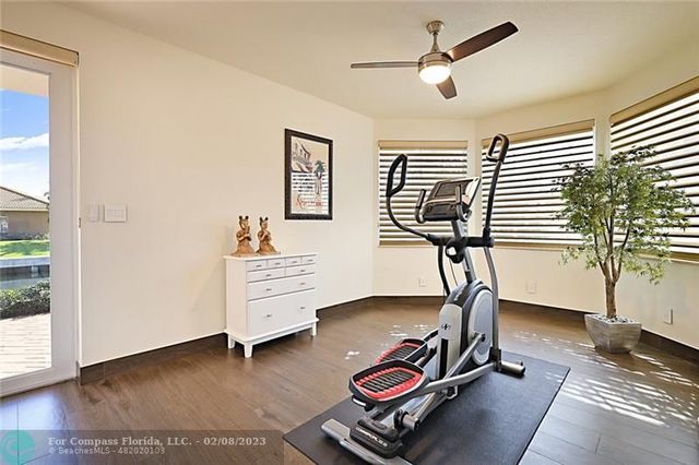 a room with gym equipment and wooden floor