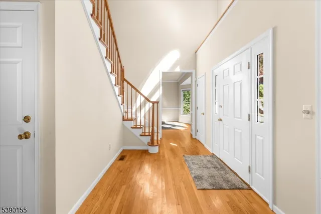 a view of a hallway with wooden floor and staircase