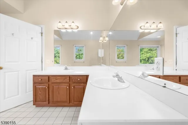 a spacious bathroom with a sink a large mirror and a bathtub