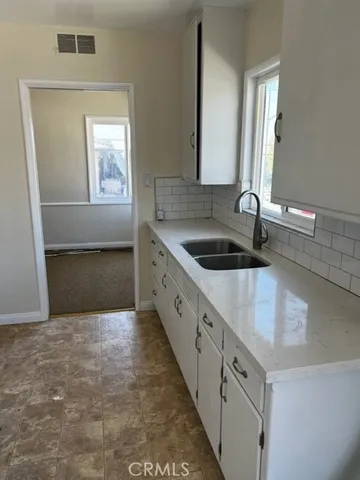 a kitchen with granite countertop a sink and a vanity