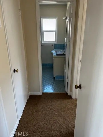 a view of a hallway with wooden floor and a cabinet