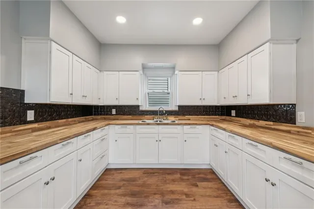 a large white kitchen with granite countertop white cabinets and a granite counter tops
