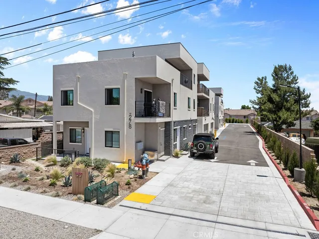 a view of a white house with a yard and balcony