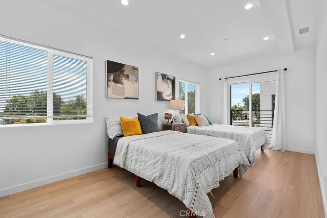 a bedroom with two beds and a large window