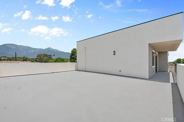 a bedroom with a bed table flowerpot and window
