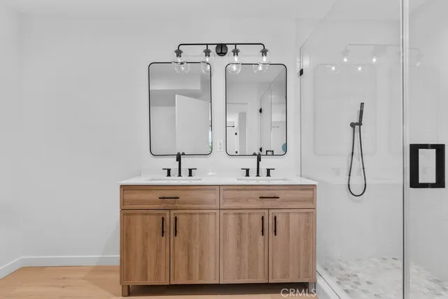 a bathroom with a double vanity sink mirror and shower