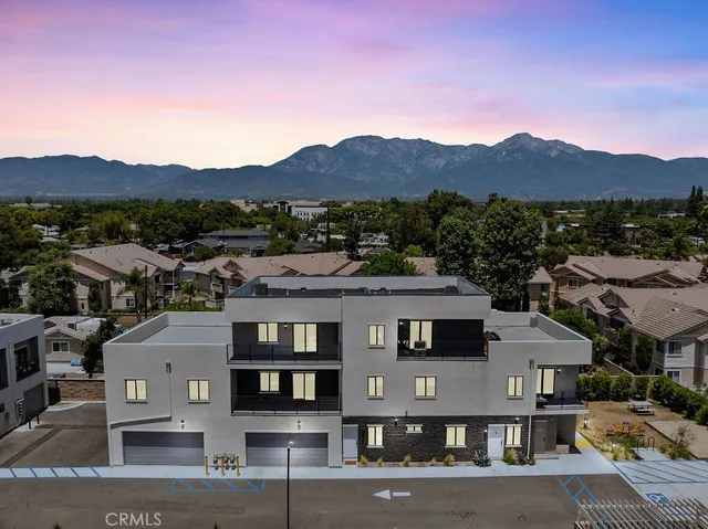a aerial view of a white house with a yard and parking space