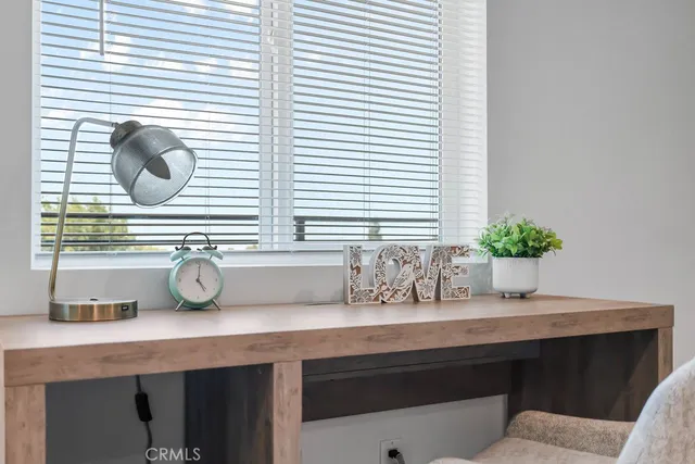 a bed sitting in a bedroom next to a lamp with potted plant
