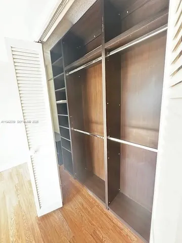 a view of closet with wooden floor