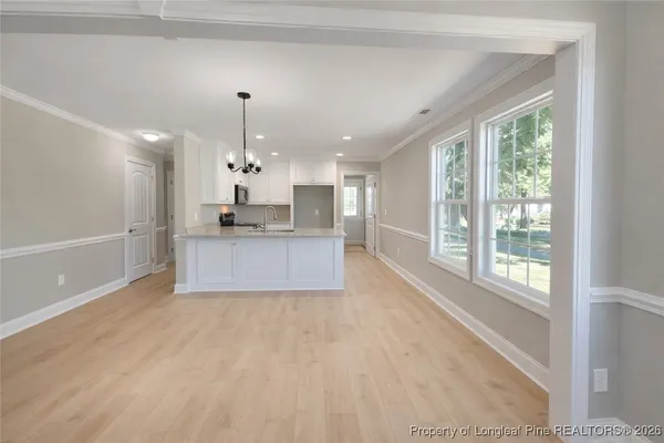 a large kitchen with granite countertop a large counter top a refrigerator and cabinets