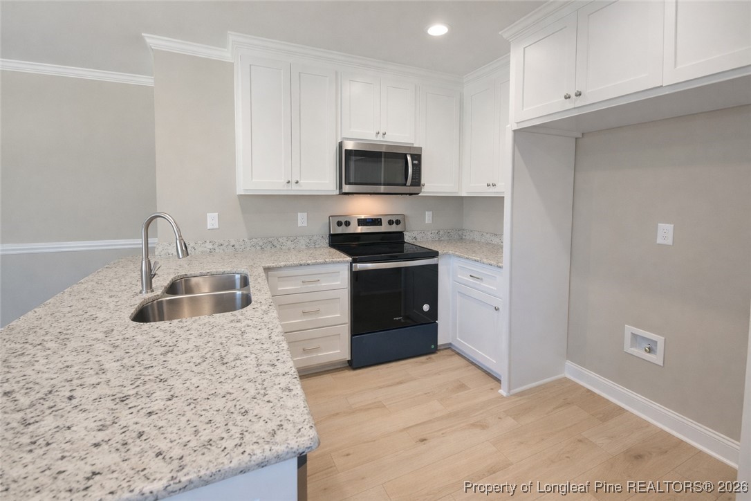 804 Holmes Street Clinton, NC 28328 - Photo 5 of 7 a kitchen with stainless steel appliances granite countertop a sink stove and refrigerator