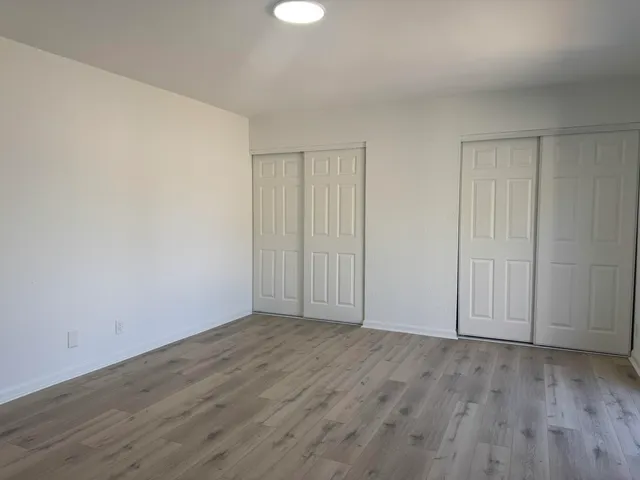 a view of an empty room with wooden floor