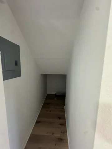 a view of a hallway with wooden floor