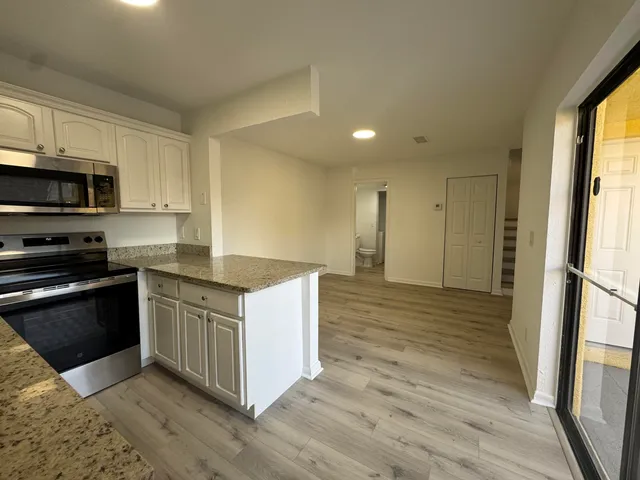 a kitchen with stainless steel appliances granite countertop a stove a sink and a refrigerator