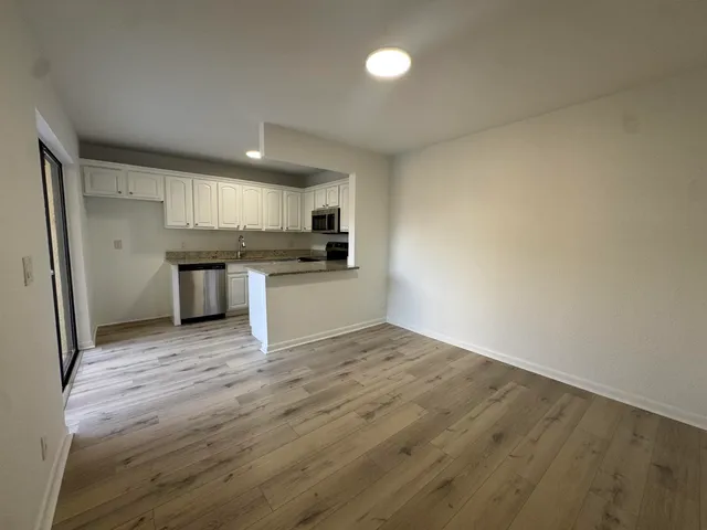 a view of a kitchen with a sink wooden floor and a refrigerator