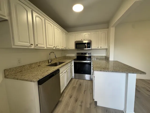a kitchen with a sink a stove top oven and white kitchen