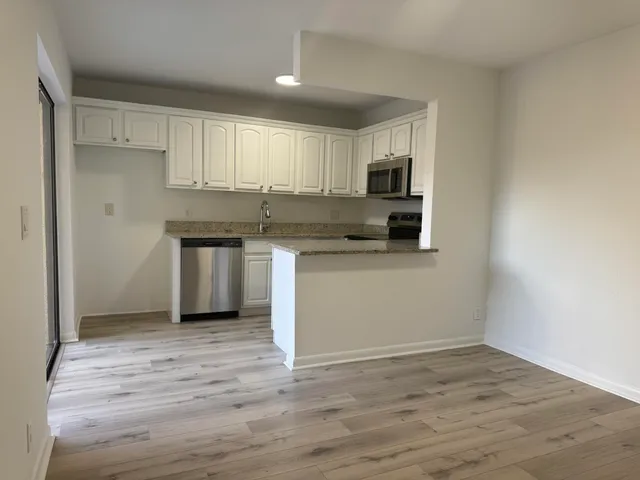 a kitchen with stainless steel appliances granite countertop a stove top oven a sink and a microwave