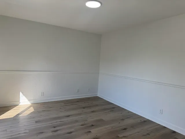 a view of a room with wooden floor and brick walls