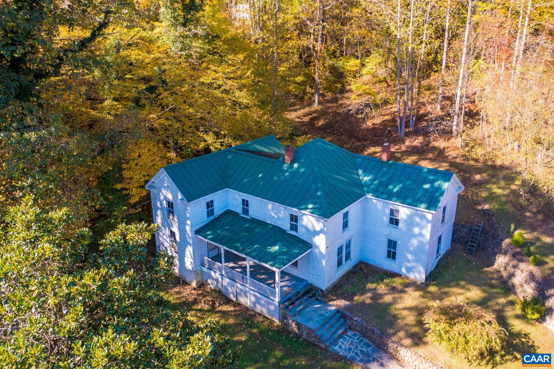 an aerial view of a house with a yard and large tree
