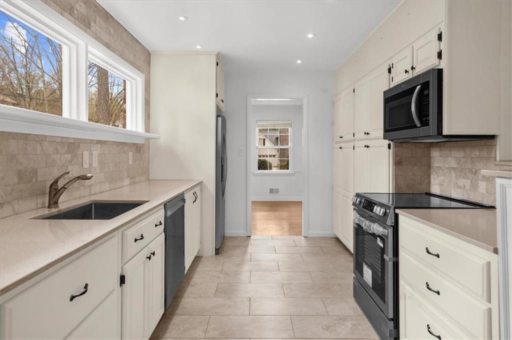 4890 High Point Road Northeast Sandy Springs, GA 30342 - Photo 12 of 35 a kitchen with stainless steel appliances granite countertop a sink and a stove