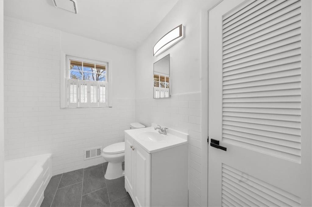 4890 High Point Road Northeast Sandy Springs, GA 30342 - Photo 19 of 35 a bathroom with a toilet sink and mirror