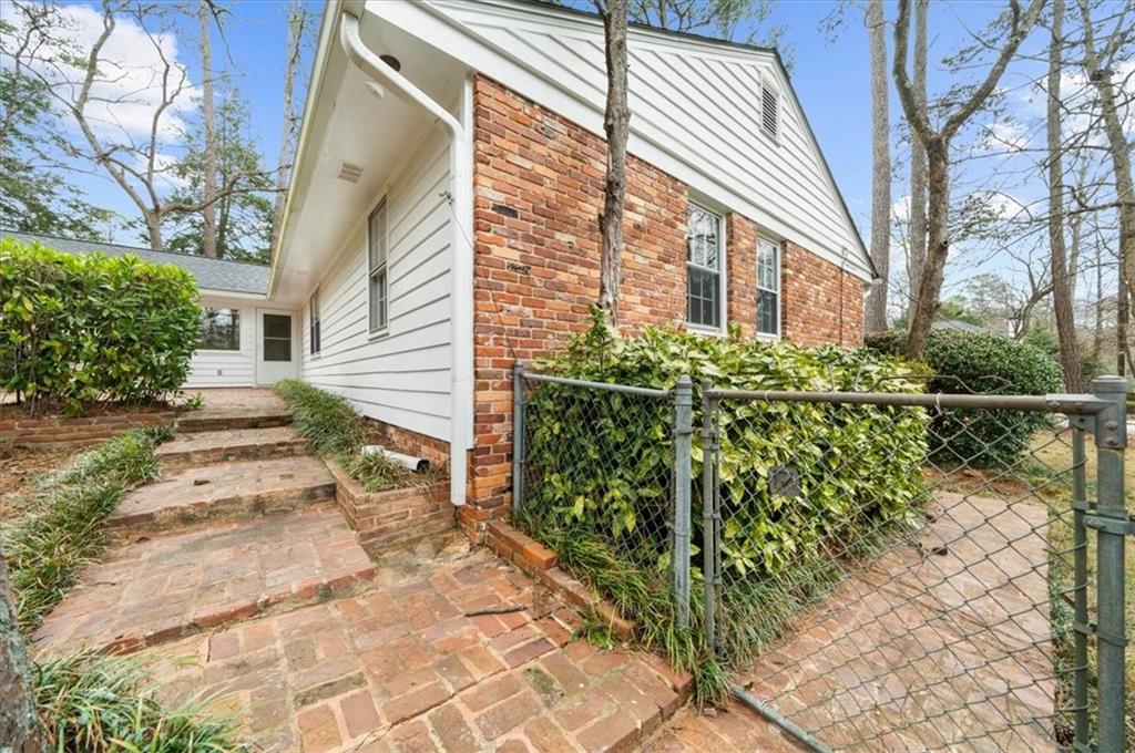 4890 High Point Road Northeast Sandy Springs, GA 30342 - Photo 34 of 35 a view of a house with a small yard and flower plants