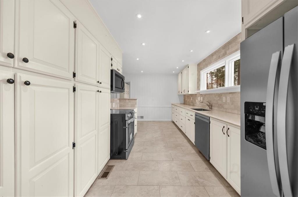 4890 High Point Road Northeast Sandy Springs, GA 30342 - Photo 9 of 35 a large kitchen with stainless steel appliances granite countertop a refrigerator and a stove