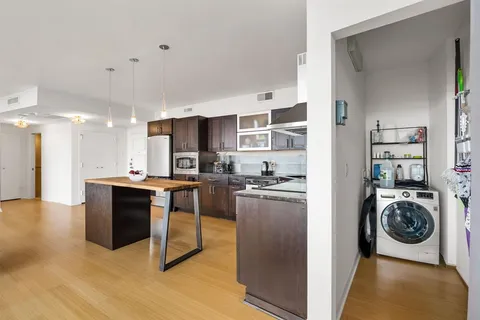 a kitchen with stainless steel appliances granite countertop a refrigerator a stove and a sink