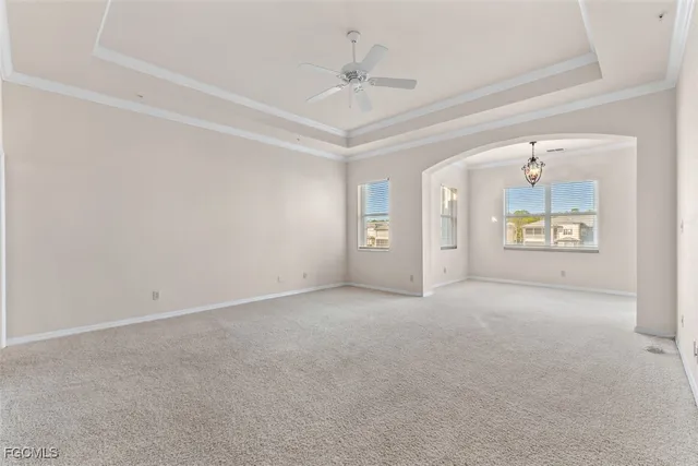 an empty room with windows and ceiling fan