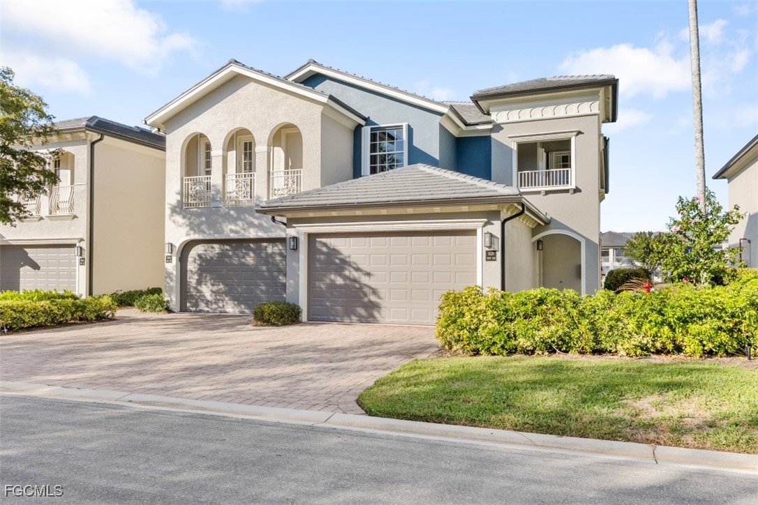 3520 Lansing Loop, Unit 203 Estero, FL 33928 - Photo 2 of 34 a front view of a house with a yard and garage