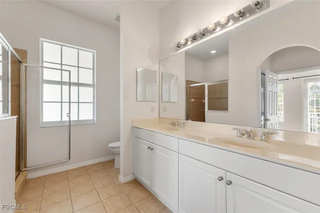 a spacious bathroom with a granite countertop sink a toilet and a mirror