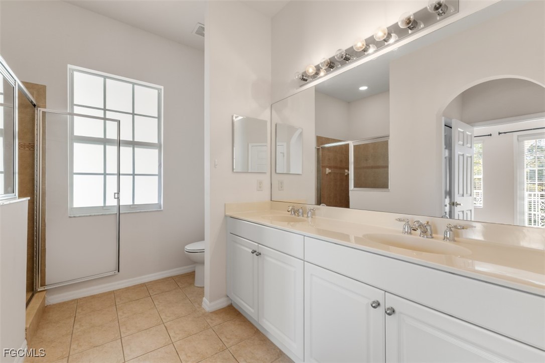 3520 Lansing Loop, Unit 203 Estero, FL 33928 - Photo 31 of 34 a spacious bathroom with a granite countertop sink a toilet and a mirror