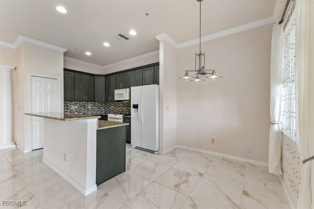 3520 Lansing Loop, Unit 203 Estero, FL 33928 - Photo 5 of 34 a kitchen with kitchen island a refrigerator and a sink