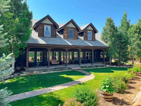 a front view of a house with yard and green space